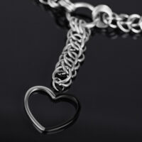 Silberne Choker Kette mit großem Herzanhänger auf schwarzem Hintergrund