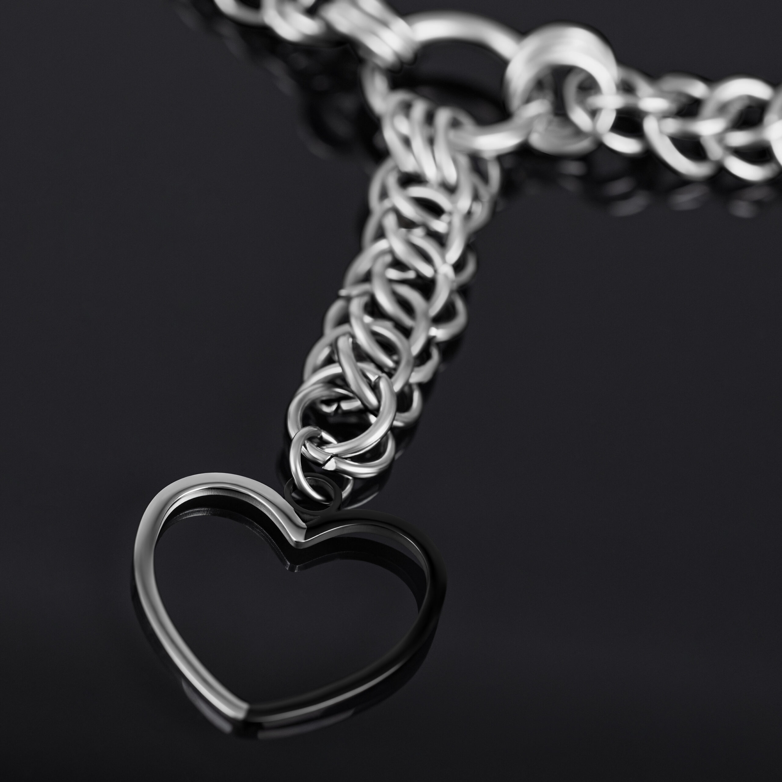 Silberne Herz Choker Kette aus Chirurgenstahl Silberne Choker Kette mit großem Herzanhänger auf schwarzem Hintergrund
