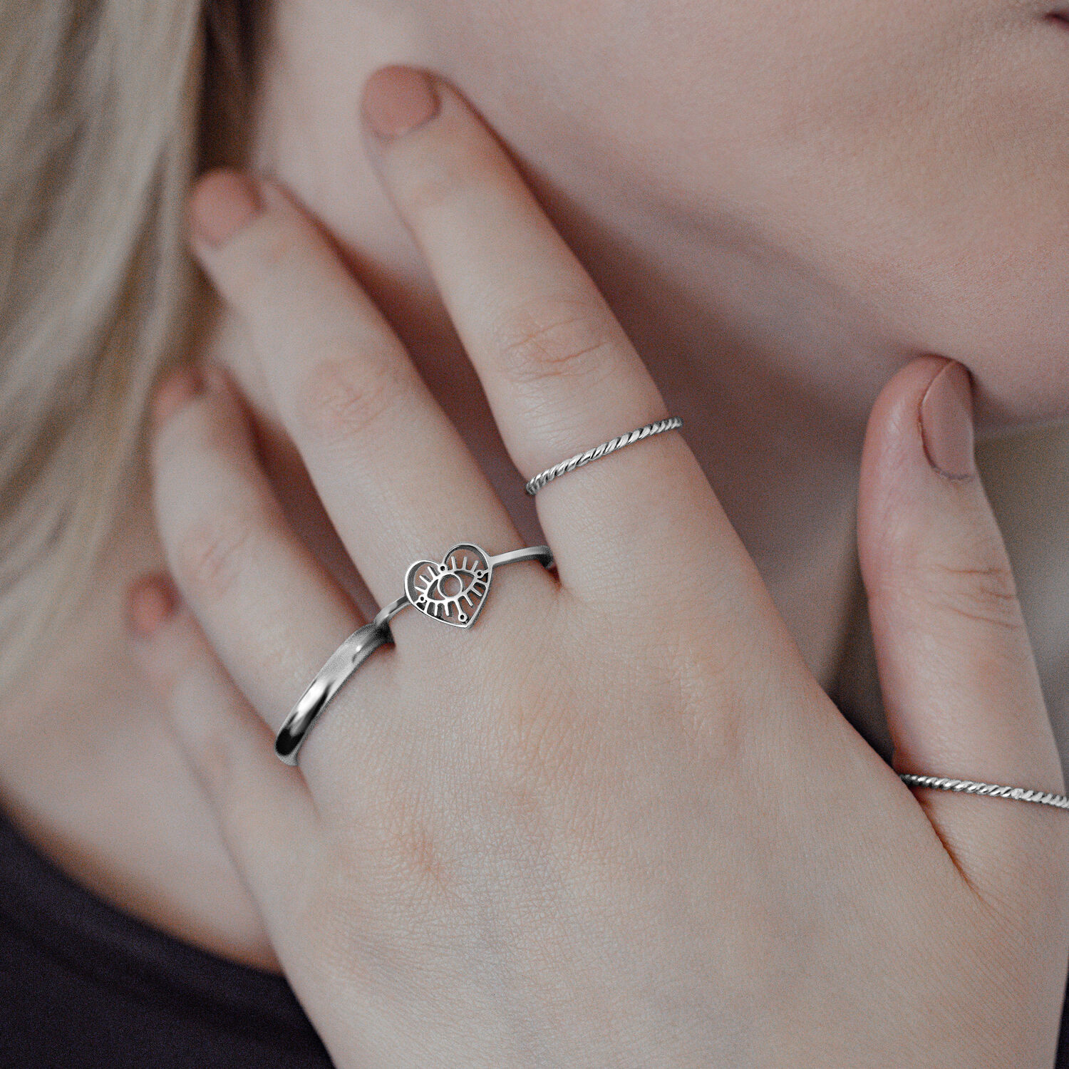 Eleganter Eye Ring aus Chirurgenstahl Silberner Eye Ring aus Chirurgenstahl an Frauenhand, Herzdesign, nahaufnahme