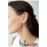 Frau mit langen Haaren trägt silberne Little Smiley Hoops an ihrem Ohr.