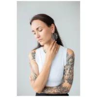 Moon Eclipse Hoops im eleganten Design Frau mit großen, runden Ohrringen in Schwarz und Silber, vor grauem Hintergrund