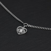 Schlichtes Herz-Augen-Armband aus Silber Silbernes Armband mit Herzanhänger auf schwarzem Hintergrund