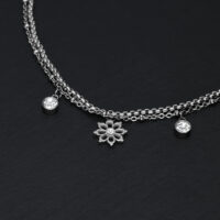 Little Floralis Armband in Silber mit Kristall Silbernes Armband auf schwarzem Hintergrund mit floralen Anhängern und Kristallen