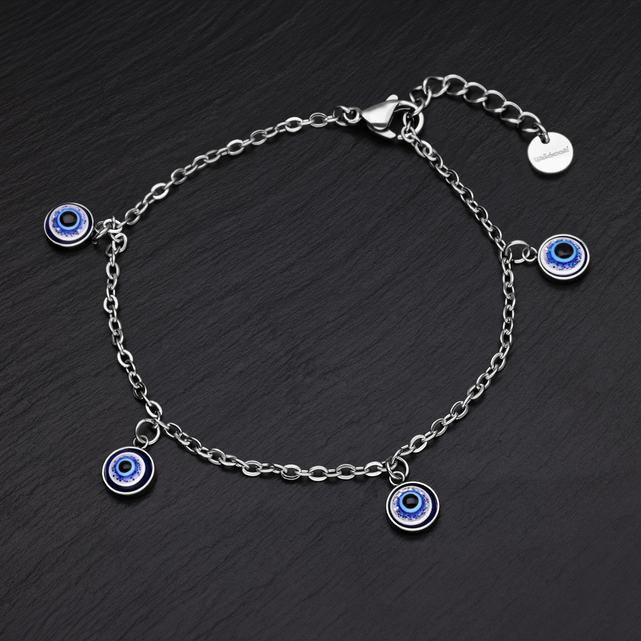 Silbernes Armband mit blauen Nazar-Anhängern auf schwarzem Hintergrund