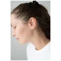 Auffälliger Ohrstecker Double Beam Crystal Silberne Ohrstecker mit Kristallen am Ohr einer Frau auf neutralem Hintergrund