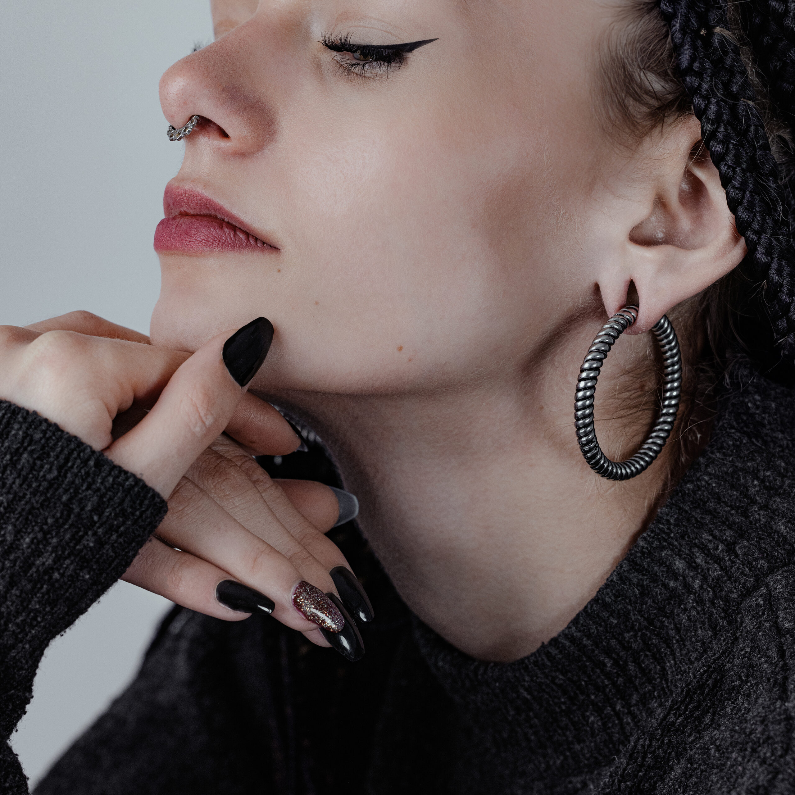 Twisted Rope Ohrgewichte aus Chirurgenstahl Frau mit großen, schwarzen Twisted Rope Ohrgewichten und dunklem Pullover