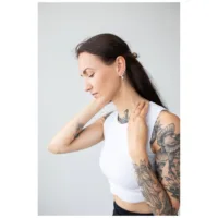 Stilvolle Oval Basic Hoops Ohrringe Frau mit tätowierten Armen trägt silberne Oval Basic Hoops vor hellem Hintergrund