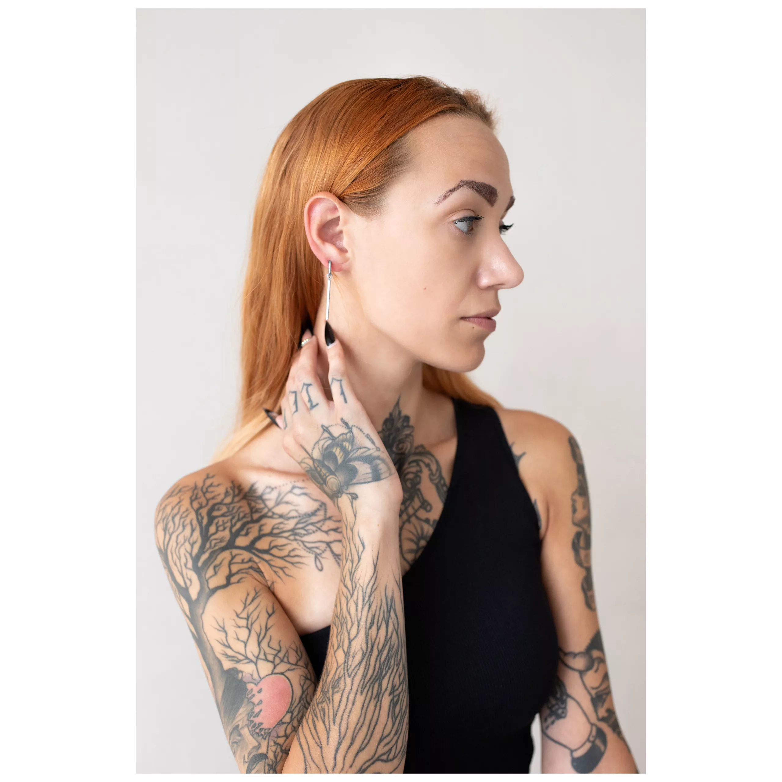Elegante Little Bar Hoops Ohrringe in Silber Frau mit roten Haaren trägt silberne Little Bar Hoops Ohrringe vor hellem Hintergrund