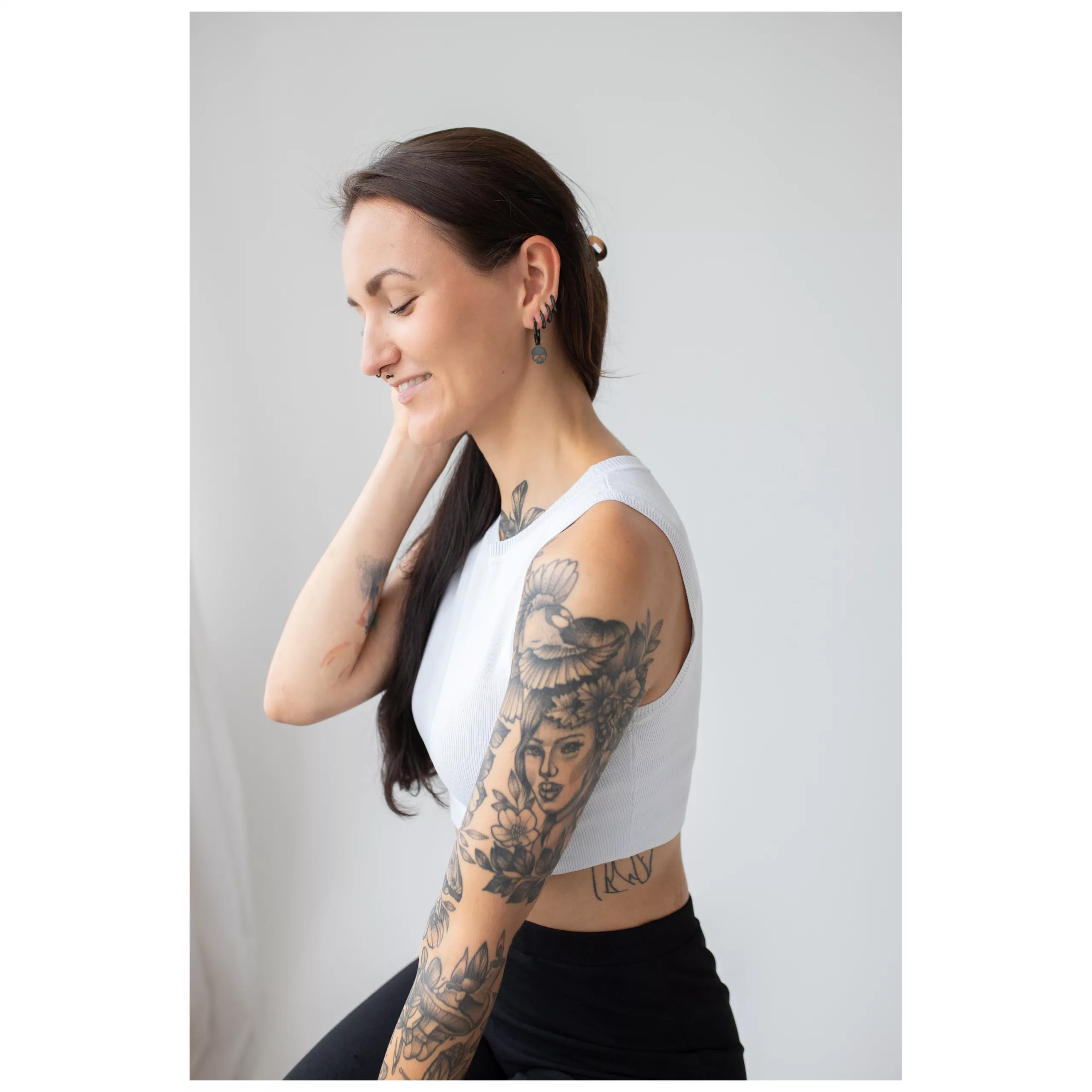Schwarze Little Skull Hoops Ohrringe Frau mit langen Haaren trägt schwarze Skull-Ohrringe vor hellem Hintergrund