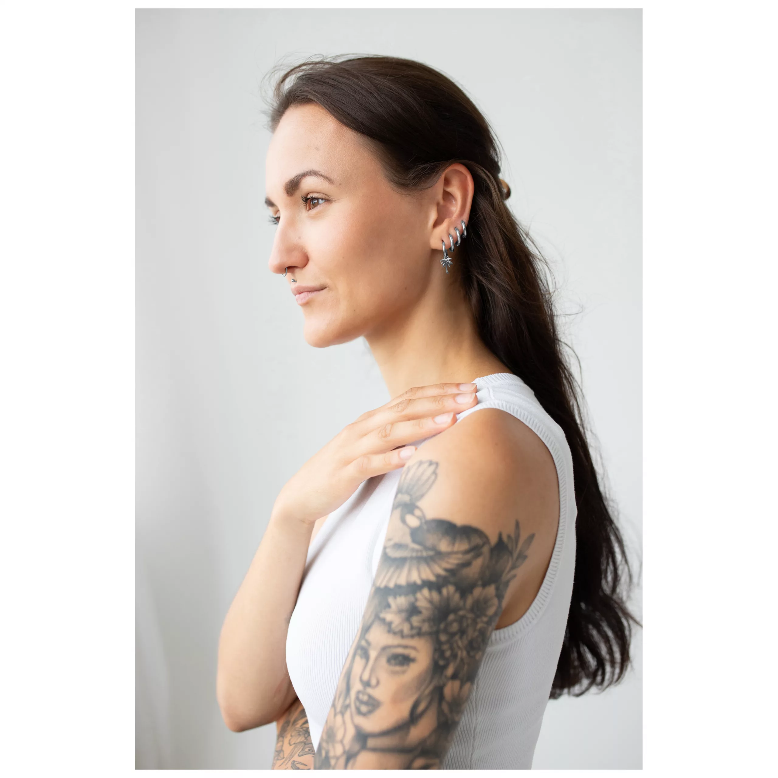 Frau mit langen dunklen Haaren trägt silberne Little Palm Tree Hoops