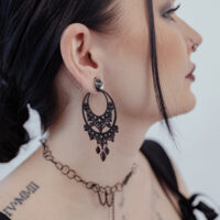Barocke Chandelier Hoops in Schwarz Schwarze barocke Ohrringe aus Chirurgenstahl am Ohr einer Frau, seitliches Profil