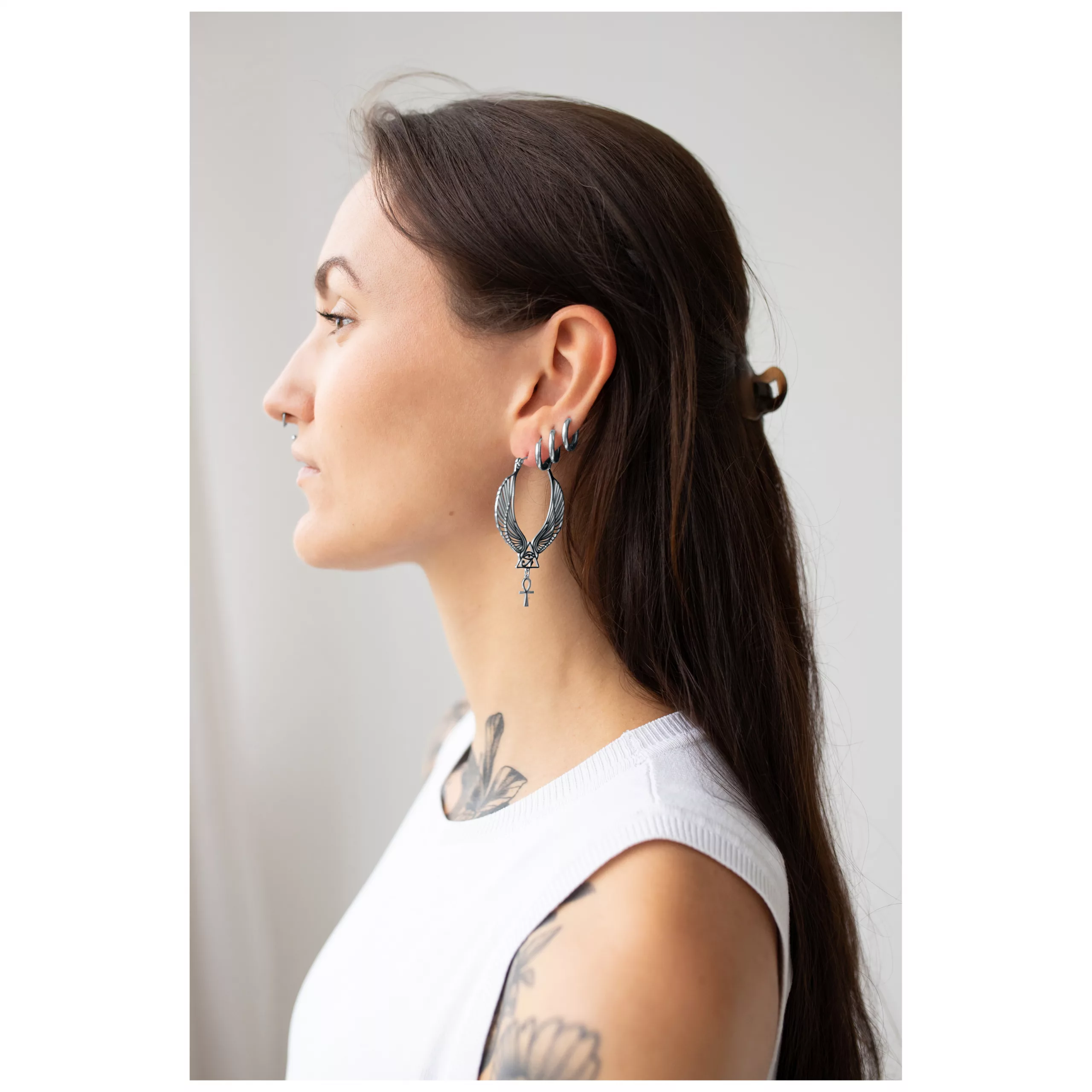 Cleopatra Hoops in Silber getragen Frau mit langen dunklen Haaren trägt große silberne Cleopatra Hoops Ohrringe