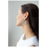 Silberne Magnolia Hoops Ohrringe im Ohr Frau mit langen Haaren trägt silberne Magnolia Hoops Ohrringe