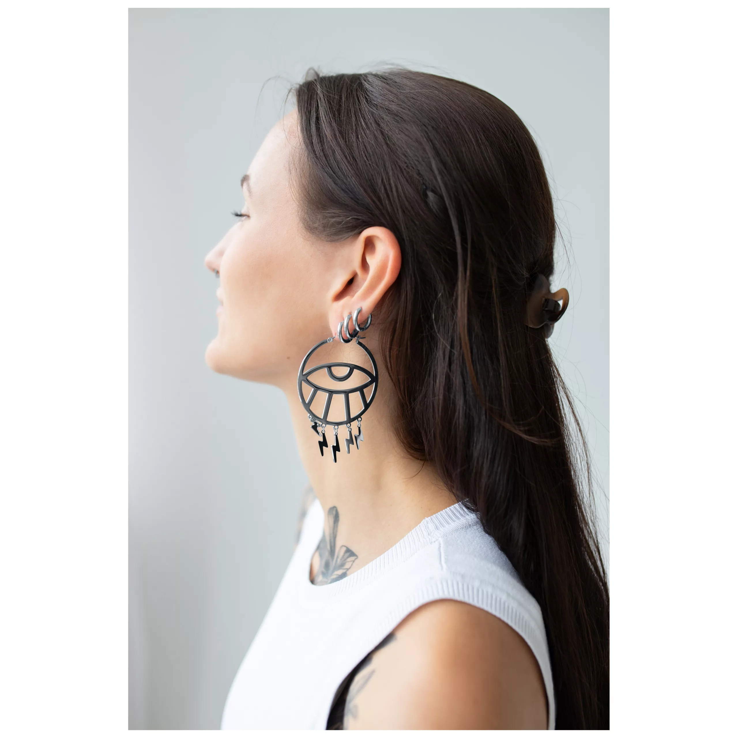Thunderflash Eye Hoops in Schwarz getragen Frau mit langen Haaren trägt große schwarze Thunderflash Eye Hoops Ohrringe seitlich