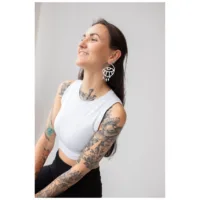 Thunderflash Eye Hoops am Ohr getragen Frau mit langen Haaren trägt auffällige Thunderflash Eye Hoops, weißes Top