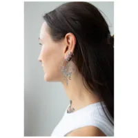 Stylische Oracle Hoops Ohrringe in Schwarz Junge Frau mit langen Haaren trägt große, schwarze Oracle Hoops Ohrringe seitlich im Profil