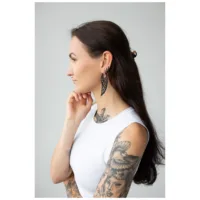 Schwarze Wing Hoops Ohrringe im eleganten Design Frau mit langen dunklen Haaren, trägt schwarze Wing Hoops Ohrringe und weißes Oberteil
