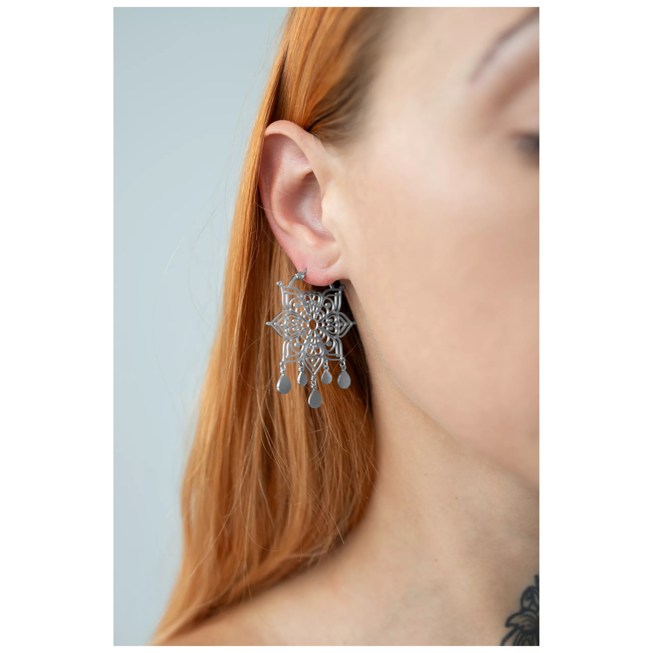 Silberne Mandala Ohrringe im eleganten Design Silberne Mandala Ohrringe getragen, auf Ohr fokussiert, blondes Haar