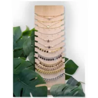 Schwarzes Display für Armbänder und Halsketten Holzdisplay mit schwarzen Kunstlederakzenten, umgeben von Pflanzen