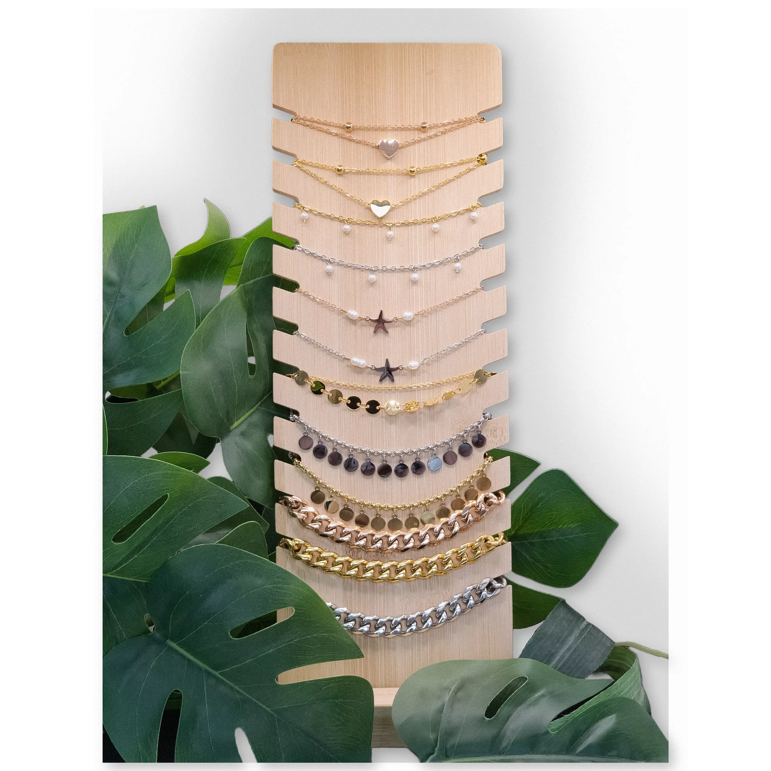Schwarzes Display für Armbänder und Halsketten Holzdisplay mit schwarzen Kunstlederakzenten, umgeben von Pflanzen