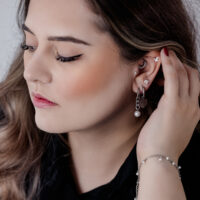 Frau mit eleganten schwarzen und silbernen Chunky Pearl Hoops und anderen Ohrpiercings