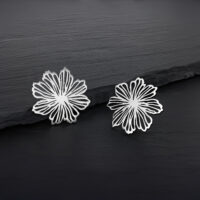 Feine Blumen Ohrstecker aus Edelstahl Zwei silberne Blumen Ohrstecker aus Edelstahl auf dunklem Hintergrund