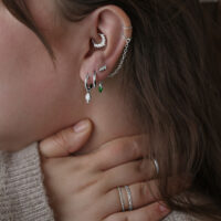 Elegante Little Tear Hoops am Ohr Frau trägt Little Tear Hoops Ohrringe aus Chirurgenstahl in verschiedenen Farben und Größen.