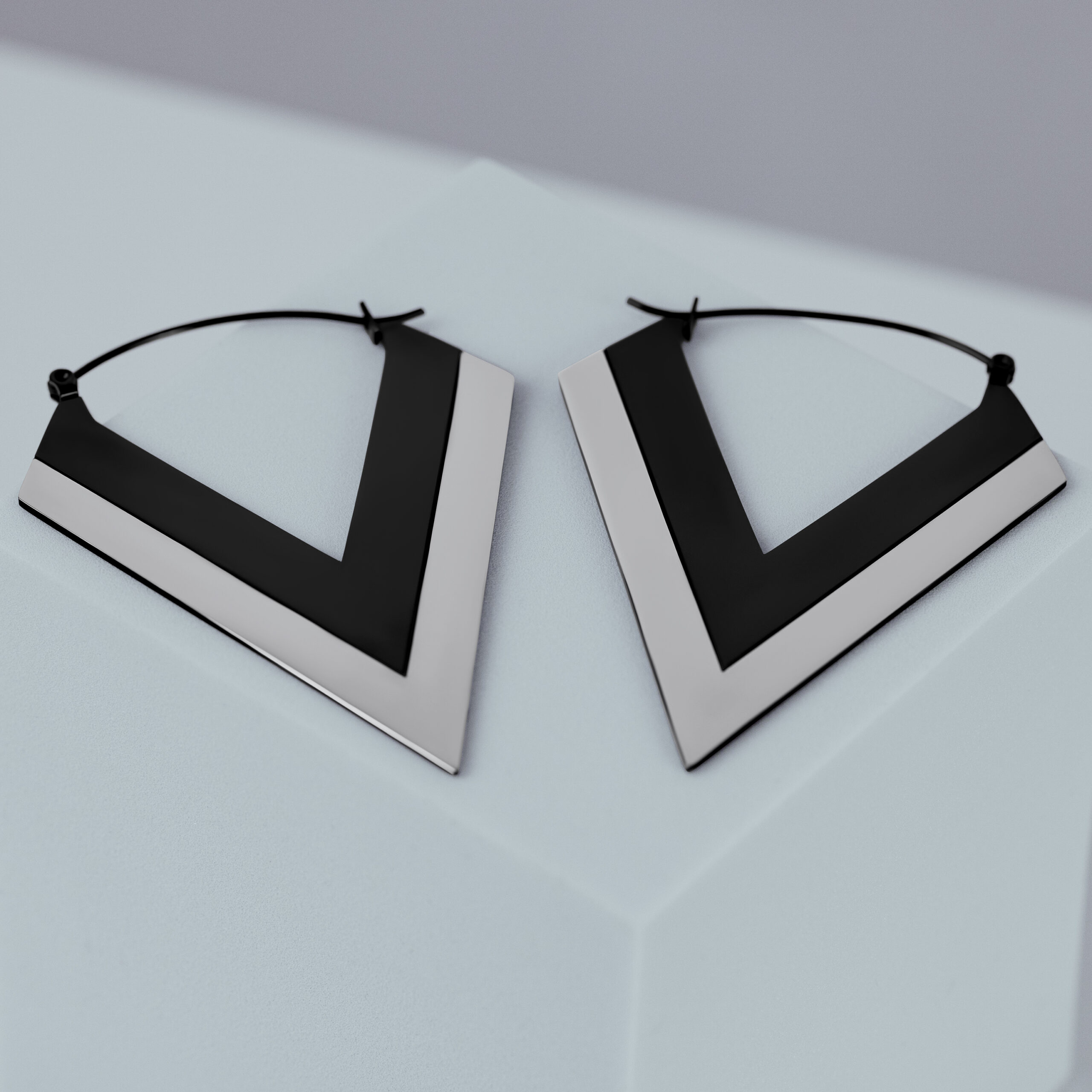 Verena Venus Silber Schwarz V Hoops Silberne und schwarze V-förmige Ohrringe auf grauem Hintergrund