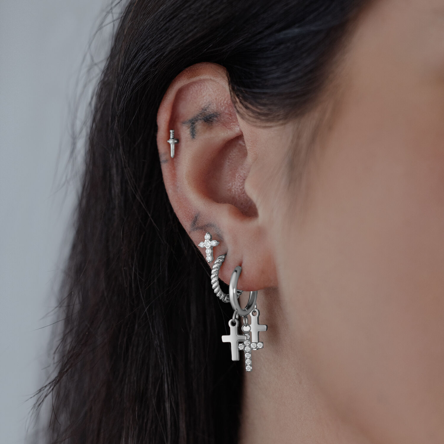 Little Dangling Cross Hoops in Silber Silberne Creolen mit hängenden Kreuzanhängern an einem Ohr