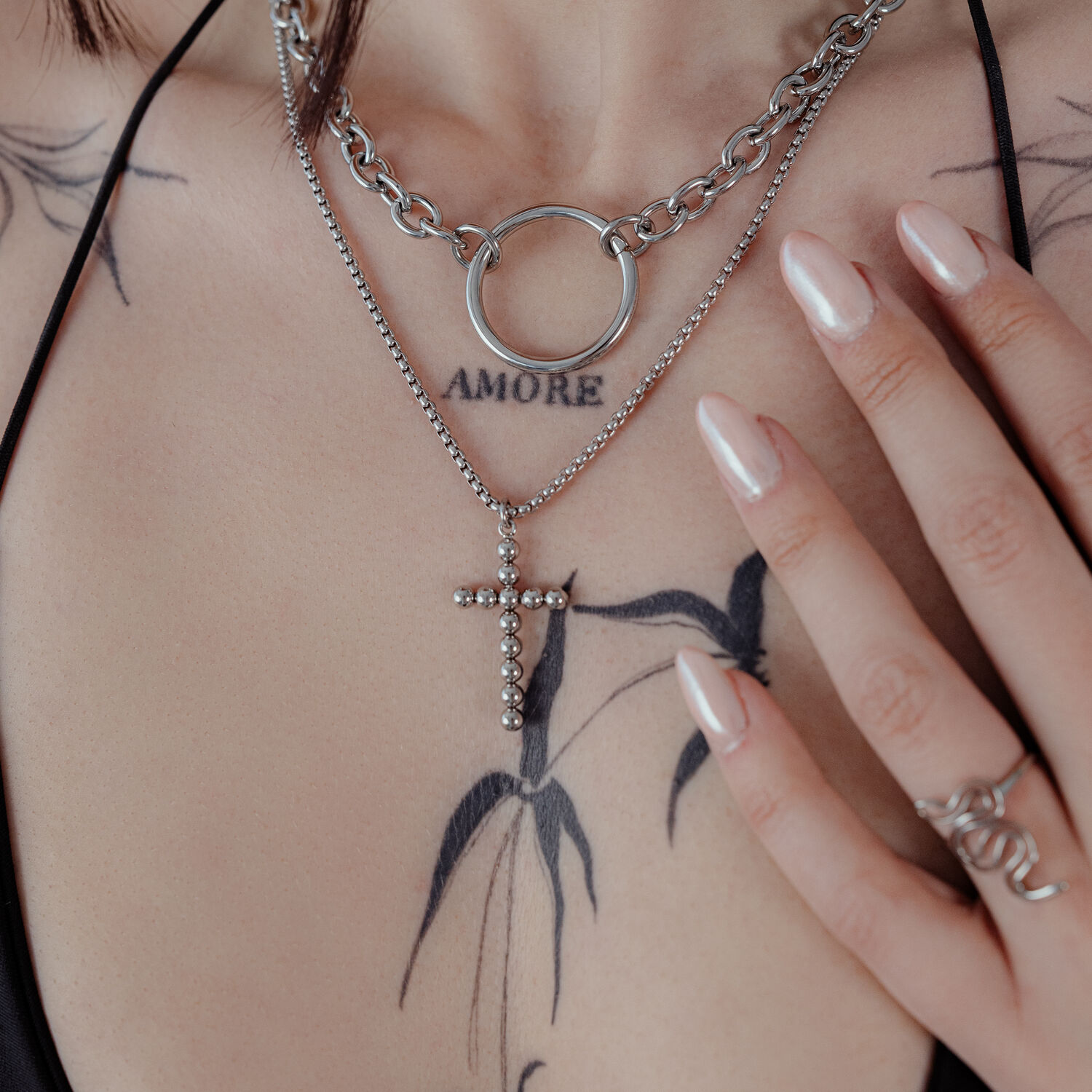 Bubble Cross Halskette in Silber Silberne Bubble Cross Halskette an einer Frau mit Tattoos, Nahaufnahme