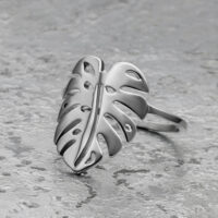 Monstera Blatt Ring in Silber aus Chirurgenstahl Silberner Monstera Blatt Ring aus Chirurgenstahl auf grauem Hintergrund