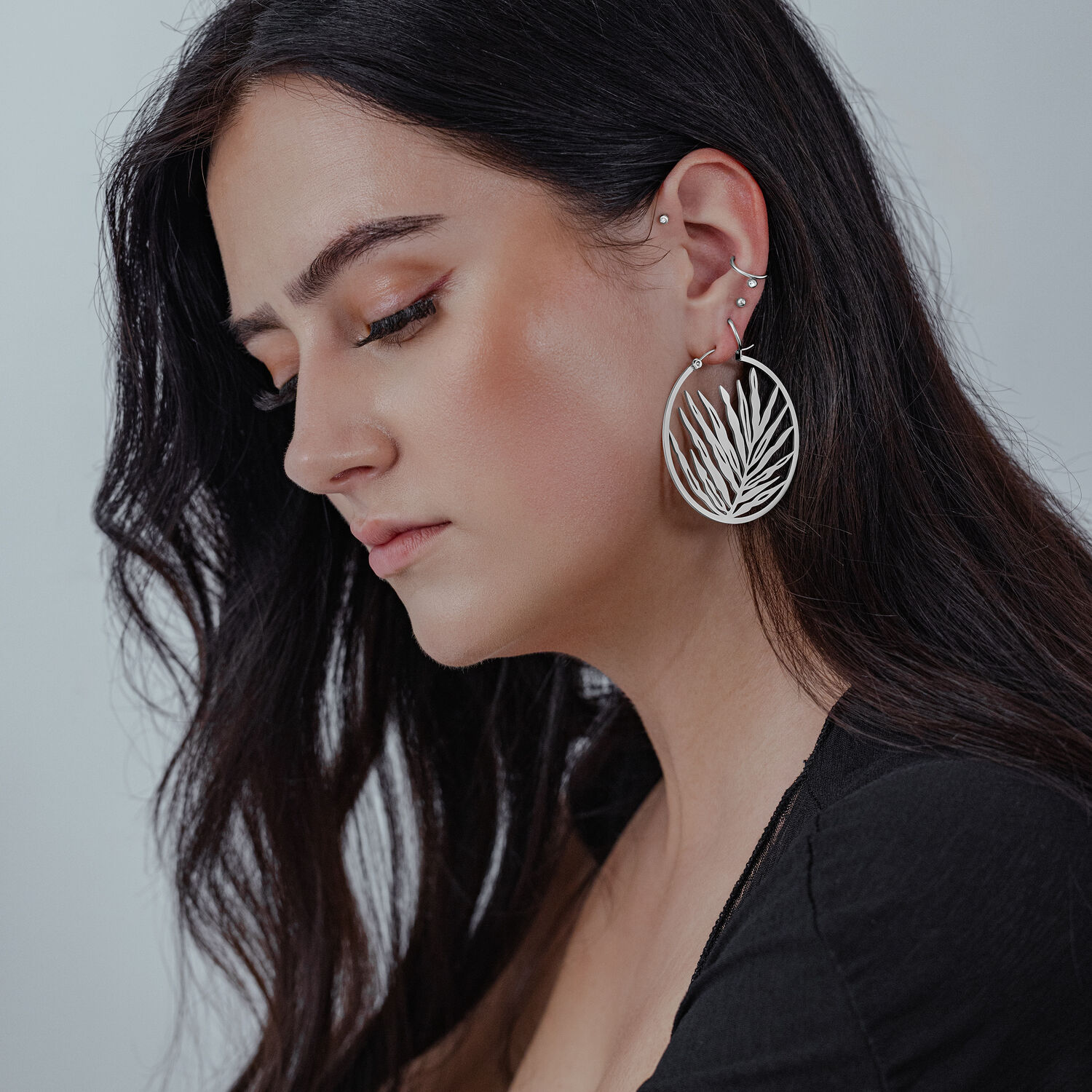 Noble Leaf Hoops Ohrringe in Silber Silberne Noble Leaf Hoops Ohrringe an Frau mit langem, dunklem Haar