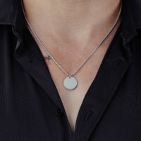 Gravierbare Basic Kette aus Chirurgenstahl Silberne Kette mit rundem Anhänger auf schwarzem Hemd getragen
