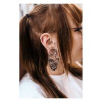 Schicker Flower Lines Clicker aus Chirurgenstahl Frau mit Flower Lines Clicker in Septum und weiteren Ohrringen, braune Haare
